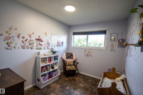 Room featuring wood-finish flooring, a window with a roller shade, and light-toned walls - 5017 55 Ave, St. Paul Town, AB - Indoor