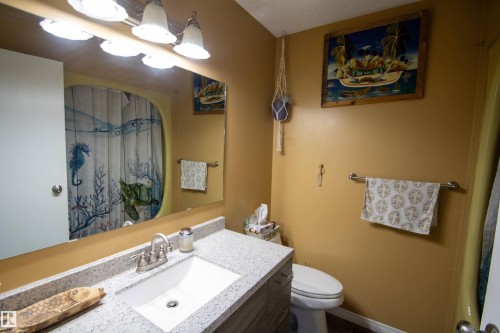 Bathroom vanity featuring a speckled countertop with an integrated rectangular sink - 5017 55 Ave, St. Paul Town, AB - Indoor Photo Showing Bathroom