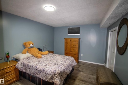 Room featuring wood-finish flooring, recessed lighting, and a window with blinds - 5017 55 Ave, St. Paul Town, AB - Indoor Photo Showing Bedroom