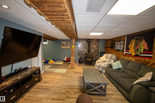Finished lower-level space featuring wood-finish flooring and recessed lighting - 5017 55 Ave, St. Paul Town, AB - Indoor Photo Showing Other Room With Fireplace