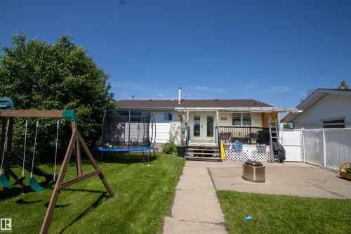 Expansive backyard featuring a concrete patio, green lawn, and mature foliage - 5017 55 Ave, St. Paul Town, AB - Outdoor
