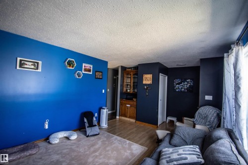 Interior room featuring wood-finish flooring and a built-in wood-finish cabinet with glass doors - 5017 55 Ave, St. Paul Town, AB - Indoor