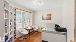 Dedicated room with wood-finish flooring, a large window with blinds, and neutral wall paint - 