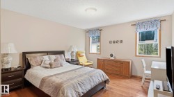 Spacious room featuring wood-finish flooring, light-toned walls, and a textured ceiling - 