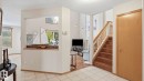 Inviting entryway featuring light-toned tile flooring, a natural wood staircase with a white balustrade, and a blonde wood door - 125 Dechene Road Nw, Edmonton, AB  - Indoor Photo Showing Other Room 