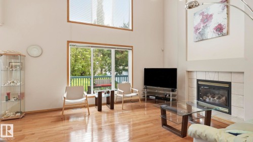 Spacious living area featuring high ceilings and wood-finish flooring - 125 Dechene Road Nw, Edmonton, AB - Indoor Photo Showing Living Room With Fireplace