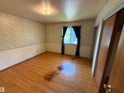 Room featuring wood-finish flooring, a window with curtains, and a ceiling-mounted light fixture - 