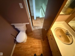 Bathroom featuring a single vanity with an integrated sink, chrome faucet, and under-sink cabinetry - 