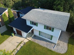 Two-story residence featuring white siding and green window shutters - 