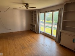 Hardwood flooring extends throughout the room, complemented by a large window feature allowing natural light - 