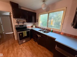Kitchen featuring wood-finish flooring and dark wood cabinetry - 