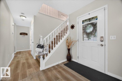 Entryway featuring wood-finish flooring and a staircase with white balusters - 6 Norfolk Close, St. Albert, AB - Indoor Photo Showing Other Room