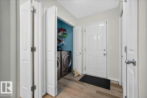 Entryway featuring light wood-finish flooring, a white paneled door, and a utility closet with bi-fold doors - 6 Norfolk Close, St. Albert, AB - Indoor Photo Showing Other Room