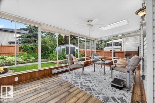 Sunroom featuring wood-finish flooring, full-height windows, a ceiling fan, and shiplap siding - 6 Norfolk Close, St. Albert, AB - Outdoor With Exterior