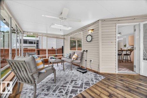Screened porch featuring wood-finish flooring, white siding, and a ceiling fan - 6 Norfolk Close, St. Albert, AB - Outdoor With Exterior