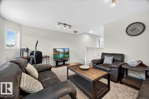 Open-concept living area featuring light-toned wall paint and an overhead track light fixture - 6 Norfolk Close, St. Albert, AB - Indoor Photo Showing Living Room
