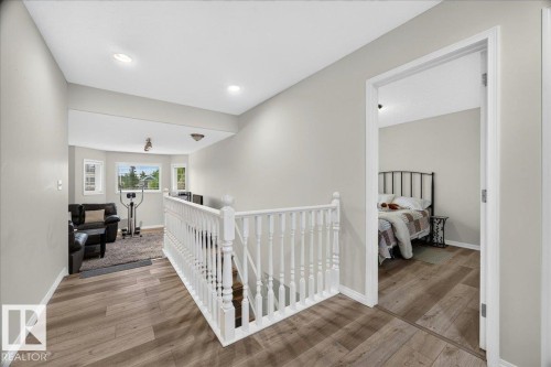 Upper-level landing featuring wood-finish flooring, white spindle railing, and recessed lighting - 6 Norfolk Close, St. Albert, AB - Indoor Photo Showing Other Room