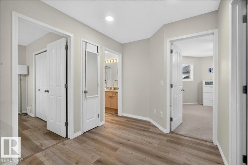 Hallway featuring wood-finish flooring, light neutral wall paint, recessed lighting, and white paneled doors - 6 Norfolk Close, St. Albert, AB - Indoor Photo Showing Other Room