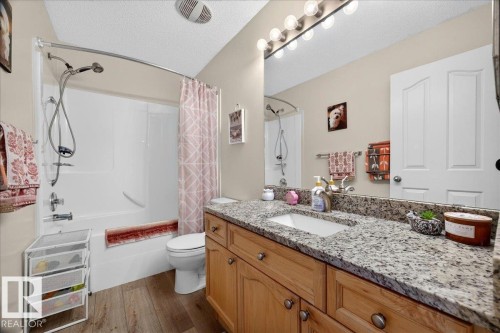 Bathroom featuring a single vanity with a granite countertop, light wood-finish cabinetry, and a rectangular undermount sink - 6 Norfolk Close, St. Albert, AB - Indoor Photo Showing Bathroom