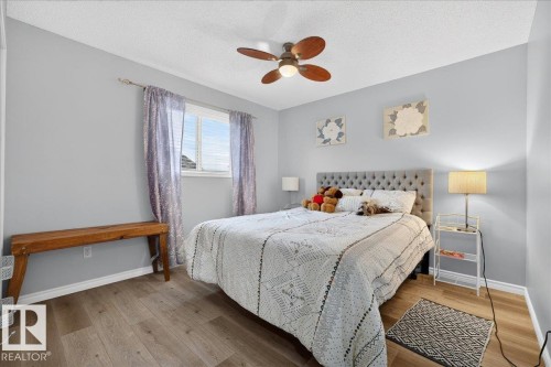Bedroom featuring light gray walls, wood-finish flooring, and a ceiling fan with integrated lighting - 6 Norfolk Close, St. Albert, AB - Indoor Photo Showing Bedroom