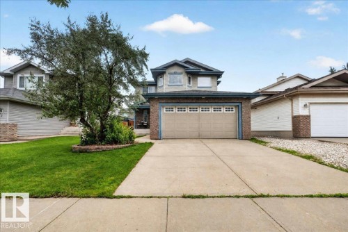 Two-story residence featuring a two-car garage with transom windows, brick accents, and light-colored siding - 6 Norfolk Close, St. Albert, AB - Outdoor With Facade