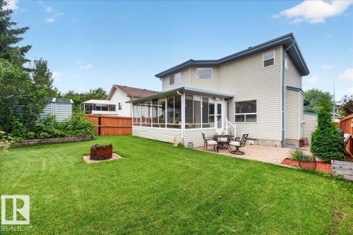 Expansive backyard featuring a green lawn, a brick paver patio, and a screened-in sunroom - 6 Norfolk Close, St. Albert, AB - Outdoor