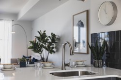 Kitchen island featuring a stainless steel undermount sink and a brushed nickel gooseneck faucet - 