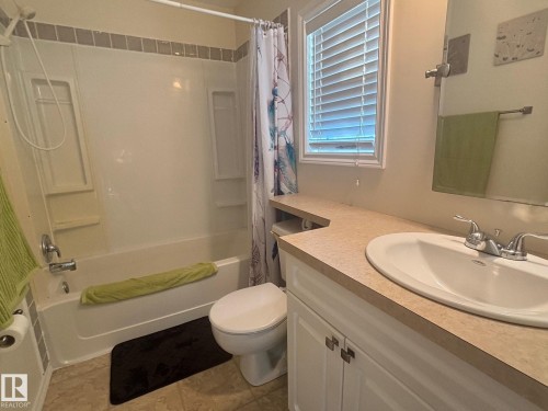 Main bath with upgraded tap and fresh tile surround. - 20 Sunset Boulevard, Spruce Grove, AB - Indoor Photo Showing Bathroom