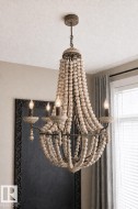 Beaded chandelier with candelabra lights, featuring an aged metal frame and light wood-tone beads - 