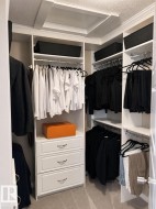 Custom closet system featuring white cabinetry and chrome hardware - 