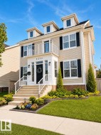 Three-story residence featuring dormer windows and beige horizontal siding - 