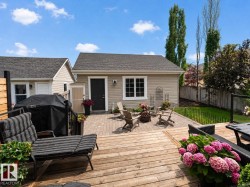 Expansive outdoor living area featuring a multi-level wood deck with a privacy screen and glass panel railing - 