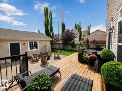 Multi-level outdoor living space featuring a wooden deck, a paved patio area, and a detached structure with siding - 