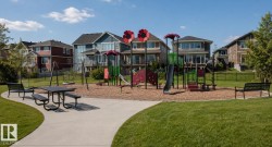 Community park featuring a playground with slides and swings, a picnic table, and benches - 