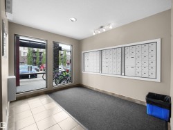 Mailroom featuring a wall-mounted mailbox system, recessed lighting, and track lighting - 