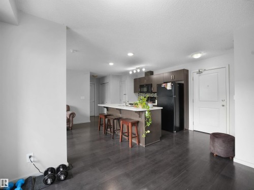 Open-concept living space featuring dark wood-finish flooring - #422 5515 7 Av Sw, Edmonton, AB - Indoor