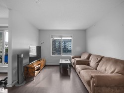 Living area featuring dark wood-finish flooring, light-toned walls, and a window with white trim - 