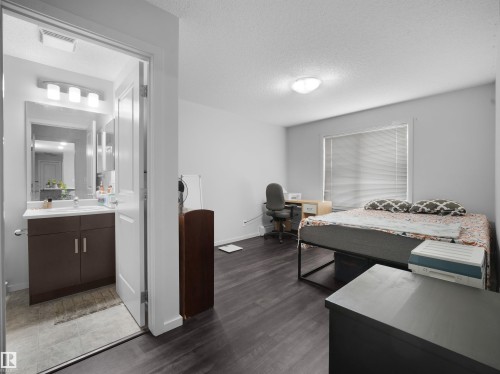 Bedroom featuring dark wood-finish flooring, a window with horizontal blinds, and a flush-mount ceiling light - #422 5515 7 Av Sw, Edmonton, AB - Indoor Photo Showing Other Room