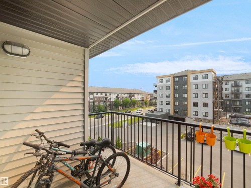 Outdoor balcony with black metal railings, light-colored horizontal siding, and a dark soffit - #422 5515 7 Av Sw, Edmonton, AB - Outdoor With Exterior