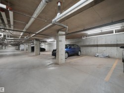 Underground parking garage featuring concrete flooring and exposed ceiling ductwork - 