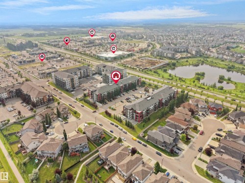Aerial view showcasing a residential neighborhood with diverse housing types, including multi-story apartment buildings and single-family homes - #422 5515 7 Av Sw, Edmonton, AB - Outdoor With View