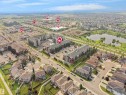 Aerial view showcasing a residential neighborhood with diverse housing types, including multi-story apartment buildings and single-family homes - #422 5515 7 Av Sw, Edmonton, AB  - Outdoor With View 
