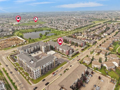 Aerial perspective showcasing a residential development with multiple multi-story buildings, surface parking, and surrounding streets - #422 5515 7 Av Sw, Edmonton, AB - Outdoor With View