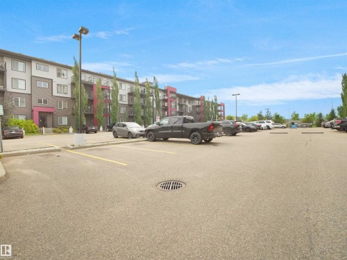 Multi-story building featuring contemporary architecture with grey and white siding and vibrant magenta accents - #422 5515 7 Av Sw, Edmonton, AB - Outdoor