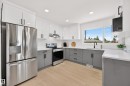 Contemporary kitchen with two-tone cabinetry, stainless steel appliances, and wood-finish flooring - 6011 93A Avenue Nw, Edmonton, AB  - Indoor Photo Showing Kitchen With Upgraded Kitchen 