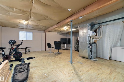 Unfinished basement featuring exposed wood beams, a window with blinds, and existing mechanical systems - 16748 118 Street Nw, Edmonton, AB - Indoor