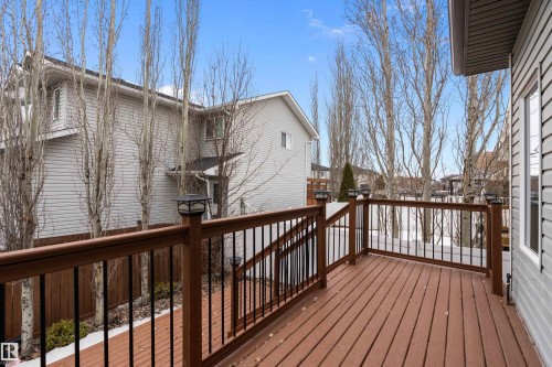Expansive outdoor deck featuring wood-finish flooring and a dark brown railing with black balusters - 16748 118 Street Nw, Edmonton, AB - Outdoor With Exterior