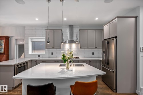 Modern kitchen featuring a spacious island with an undermount sink and pendant lighting - 14221 101 Avenue Nw, Edmonton, AB - Indoor Photo Showing Kitchen With Upgraded Kitchen