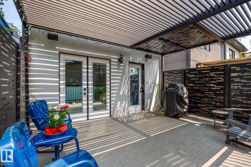 Expansive outdoor patio featuring a slatted pergola overhead and a modern privacy screen - 14221 101 Avenue Nw, Edmonton, AB - Outdoor With Deck Patio Veranda With Exterior