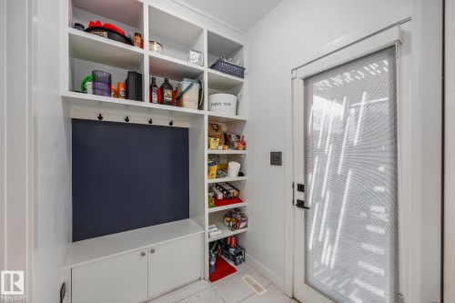 Built-in mudroom shelving with integrated coat hooks and lower cabinetry - 14221 101 Avenue Nw, Edmonton, AB - Indoor